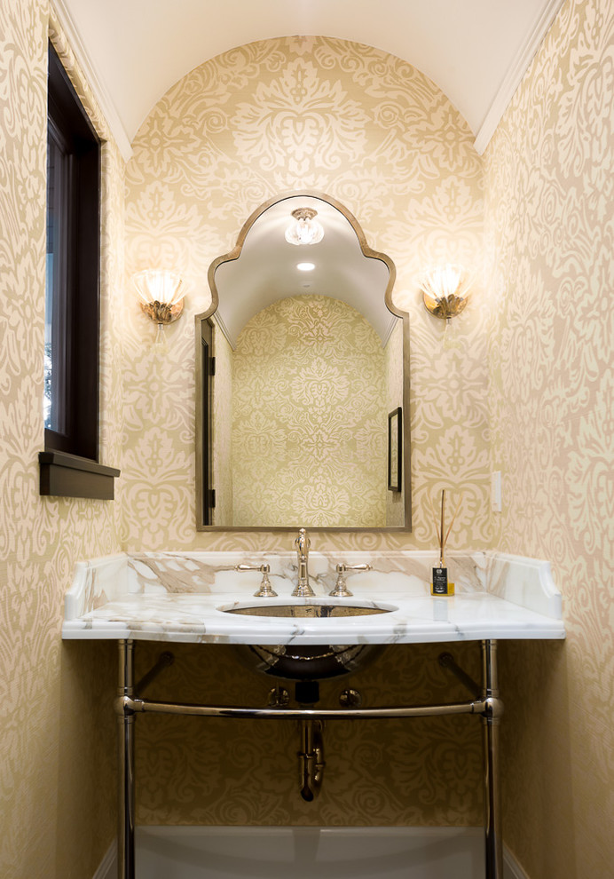 Mediterrane Gästetoilette mit beiger Wandfarbe, Unterbauwaschbecken, offenen Schränken, Marmor-Waschbecken/Waschtisch und weißer Waschtischplatte in Los Angeles
