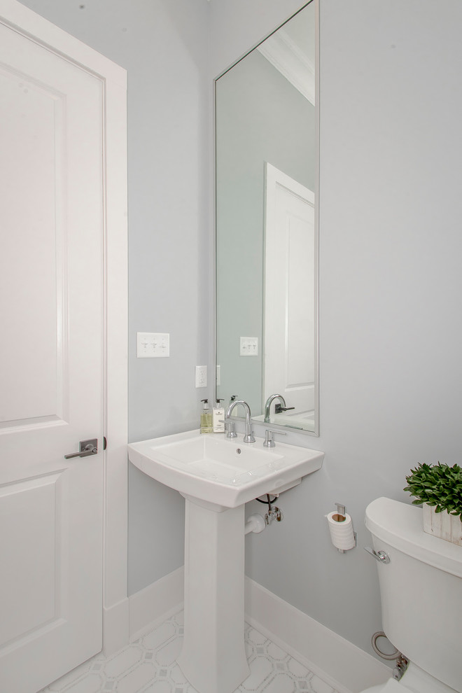 Immagine di un bagno di servizio classico di medie dimensioni con WC a due pezzi, pareti grigie, pavimento in laminato, lavabo a colonna e pavimento bianco