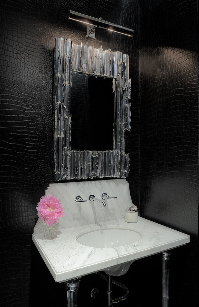 Klassisk inredning av ett toalett, med ett undermonterad handfat och svarta väggar