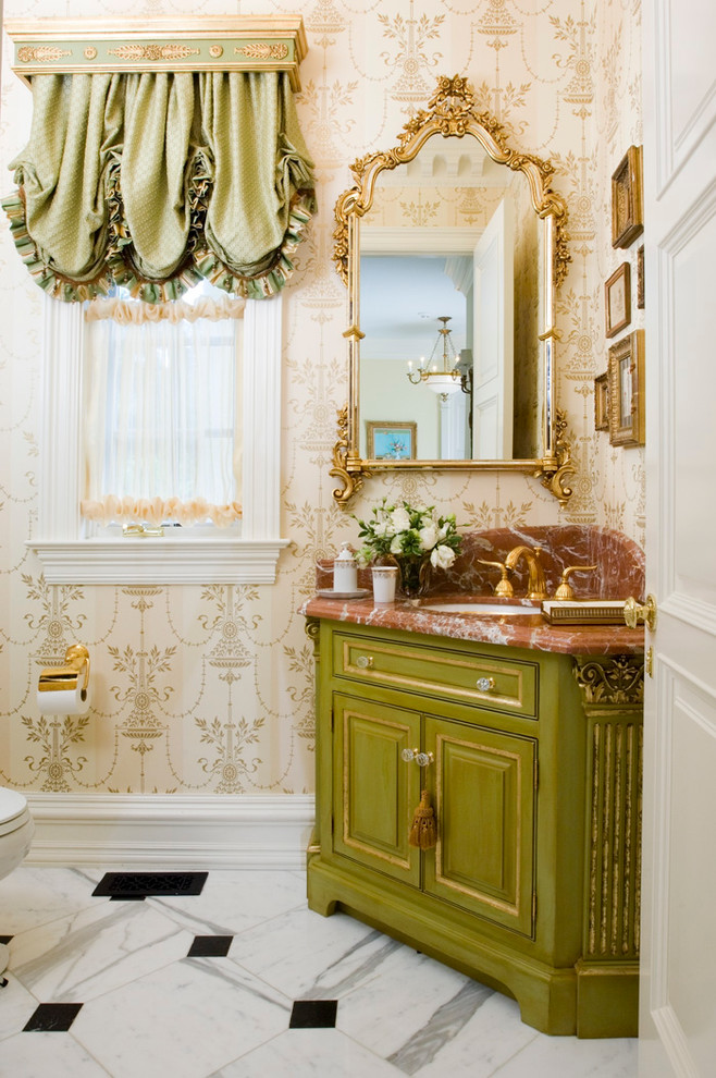 На фото: туалет в классическом стиле с врезной раковиной, фасадами с выступающей филенкой, зелеными фасадами, бежевыми стенами и коричневой столешницей