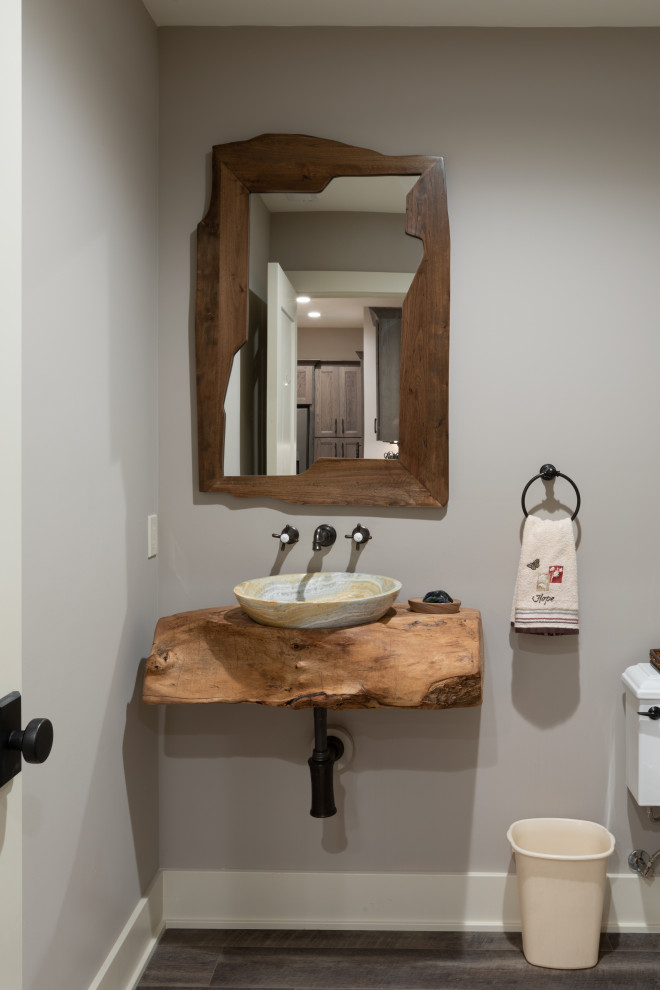 Inspiration för mellanstora rustika brunt toaletter, med grå väggar, mörkt trägolv, ett fristående handfat, träbänkskiva och brunt golv