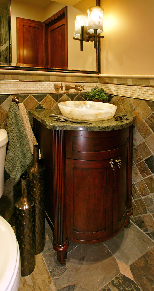 Photo of a small classic cloakroom in Minneapolis with a vessel sink, dark wood cabinets, granite worktops, green tiles, stone tiles, beige walls, a two-piece toilet, slate flooring and recessed-panel cabinets.
