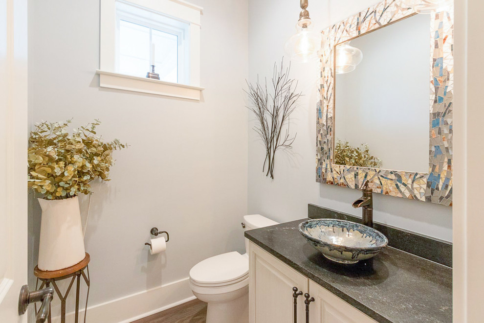 Medium sized country cloakroom in Atlanta with raised-panel cabinets, white cabinets, a two-piece toilet, grey walls, dark hardwood flooring, a vessel sink, soapstone worktops, brown floors and black worktops.