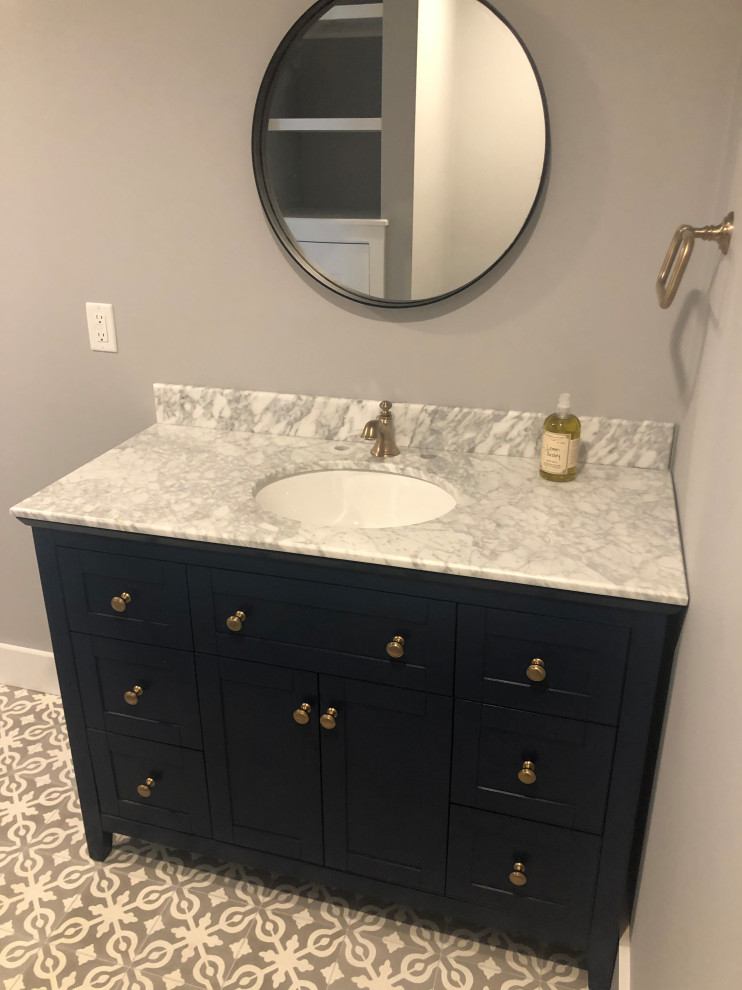 Mid-sized elegant porcelain tile and multicolored floor powder room photo in Boston with shaker cabinets, black cabinets, gray walls, an undermount sink, granite countertops and gray countertops