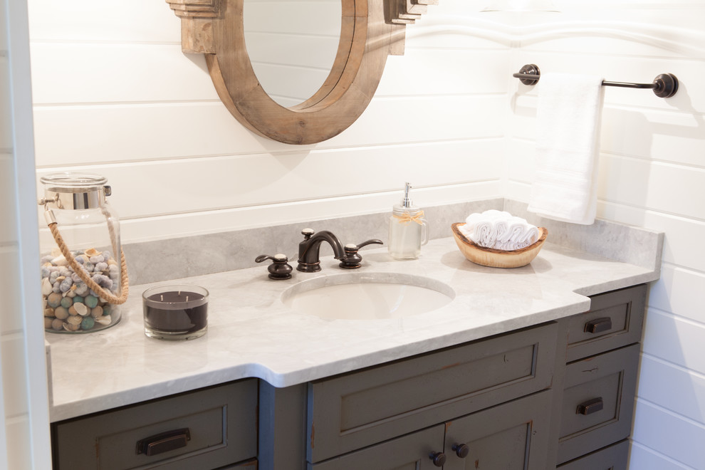 Inspiration for a small farmhouse cloakroom in Chicago with a submerged sink, distressed cabinets, marble worktops, a two-piece toilet, porcelain tiles, white walls, recessed-panel cabinets, grey tiles and white tiles.