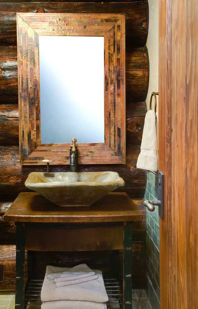 Cette photo montre un WC et toilettes montagne en bois brun de taille moyenne avec une vasque, un plan de toilette en bois, un carrelage vert, un mur marron, un placard en trompe-l'oeil, WC séparés et un plan de toilette marron.