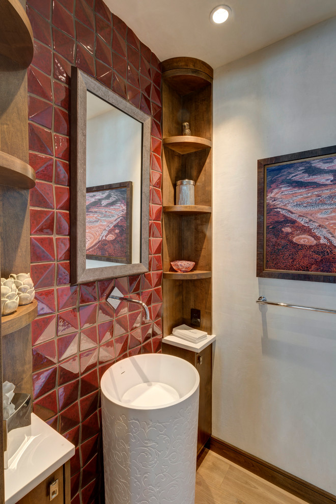 Foto på ett litet rustikt toalett, med släta luckor, skåp i mellenmörkt trä, röd kakel, beige väggar, mellanmörkt trägolv och ett piedestal handfat