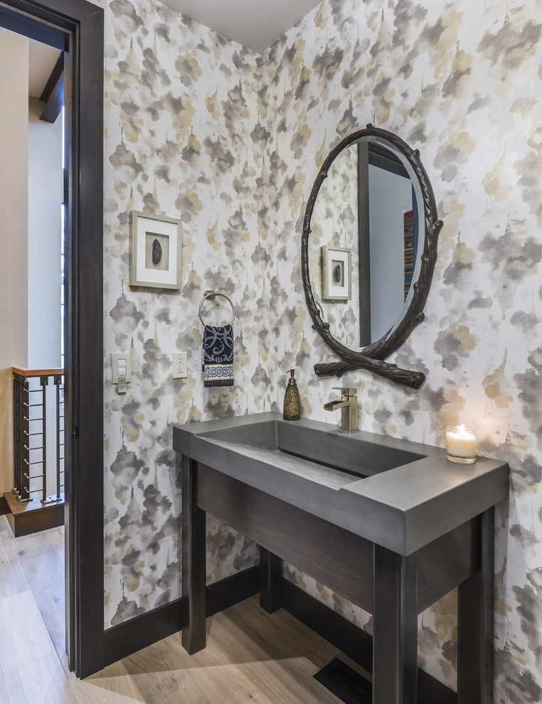 Imagen de aseo rústico con puertas de armario grises, paredes multicolor, suelo de madera clara, lavabo integrado, suelo beige y encimeras grises