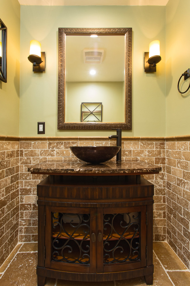 Aménagement d'un petit WC et toilettes sud-ouest américain en bois foncé avec un placard en trompe-l'oeil, WC séparés, un carrelage beige, du carrelage en travertin, un mur vert, un sol en travertin, une vasque, un plan de toilette en granite et un sol marron.