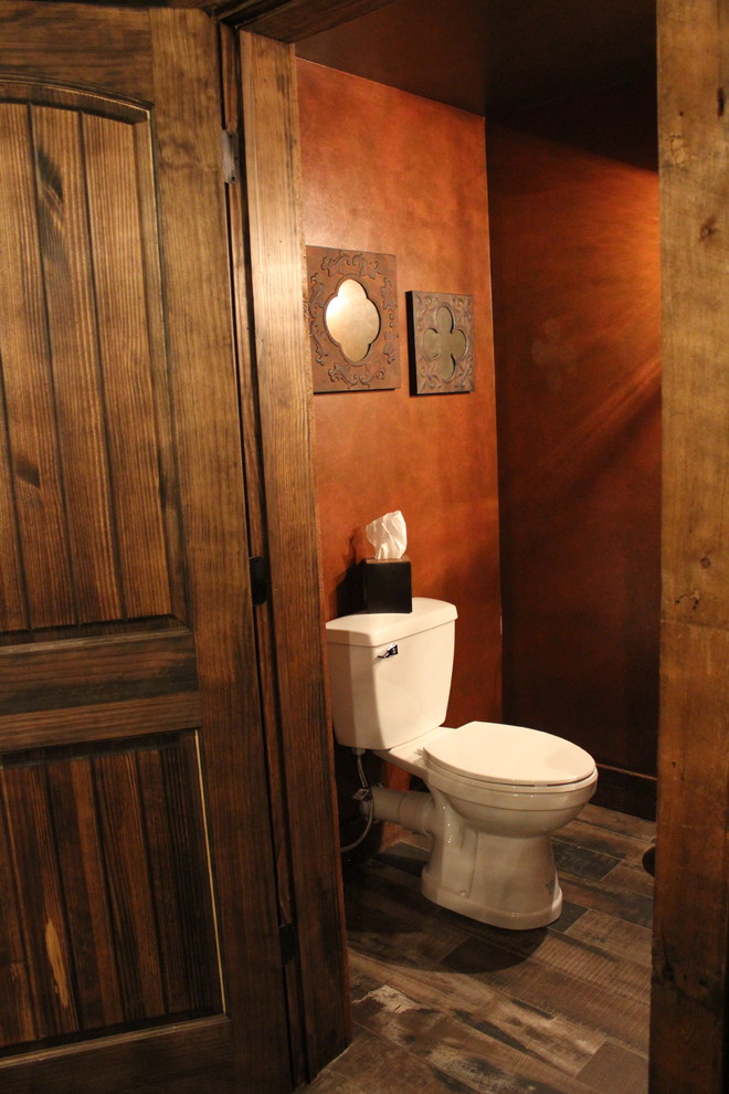 Réalisation d'un WC et toilettes chalet de taille moyenne avec WC séparés, un mur rouge, une vasque, un plan de toilette en granite et un plan de toilette gris.