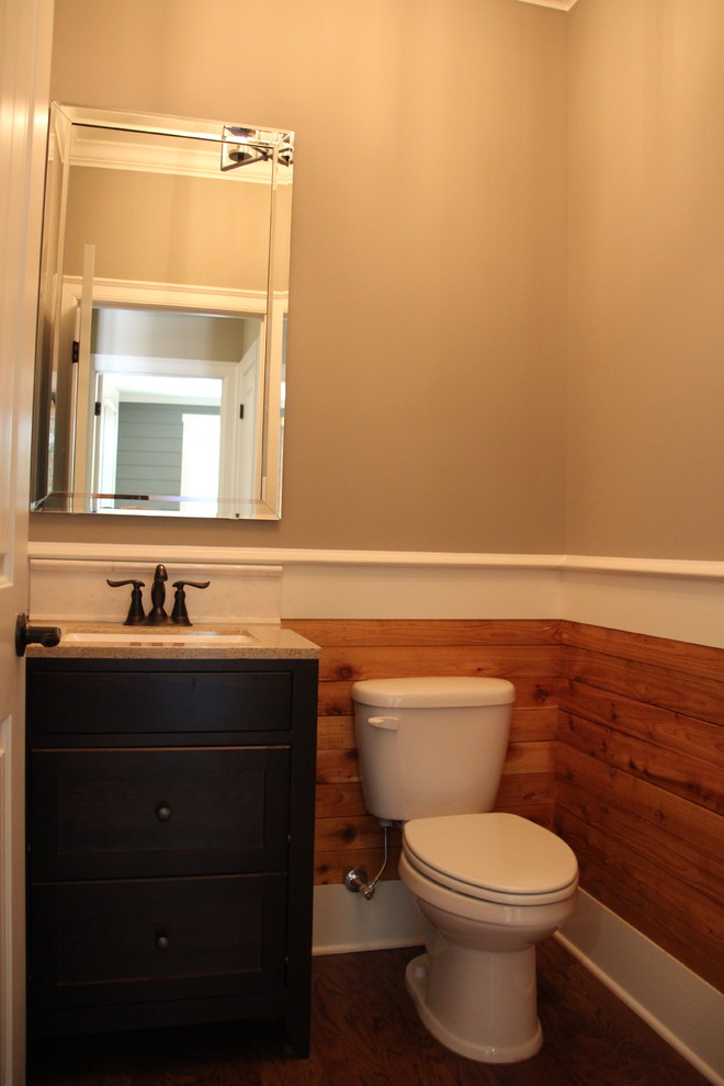Idée de décoration pour un WC et toilettes chalet en bois foncé avec WC à poser, un mur beige, un sol en bois brun, un lavabo encastré, un plan de toilette en granite et un sol marron.