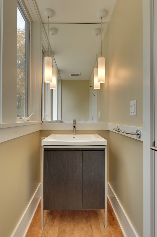 Imagen de aseo actual con lavabo integrado, armarios tipo mueble y puertas de armario de madera en tonos medios