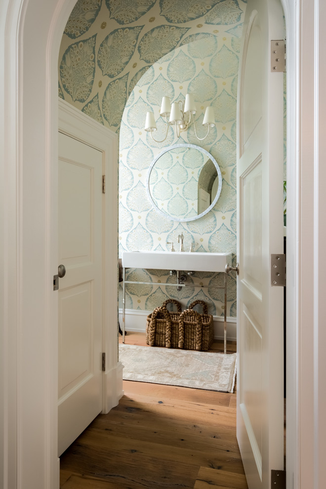 Foto de aseo clásico con paredes verdes, suelo de madera en tonos medios, lavabo suspendido y suelo marrón