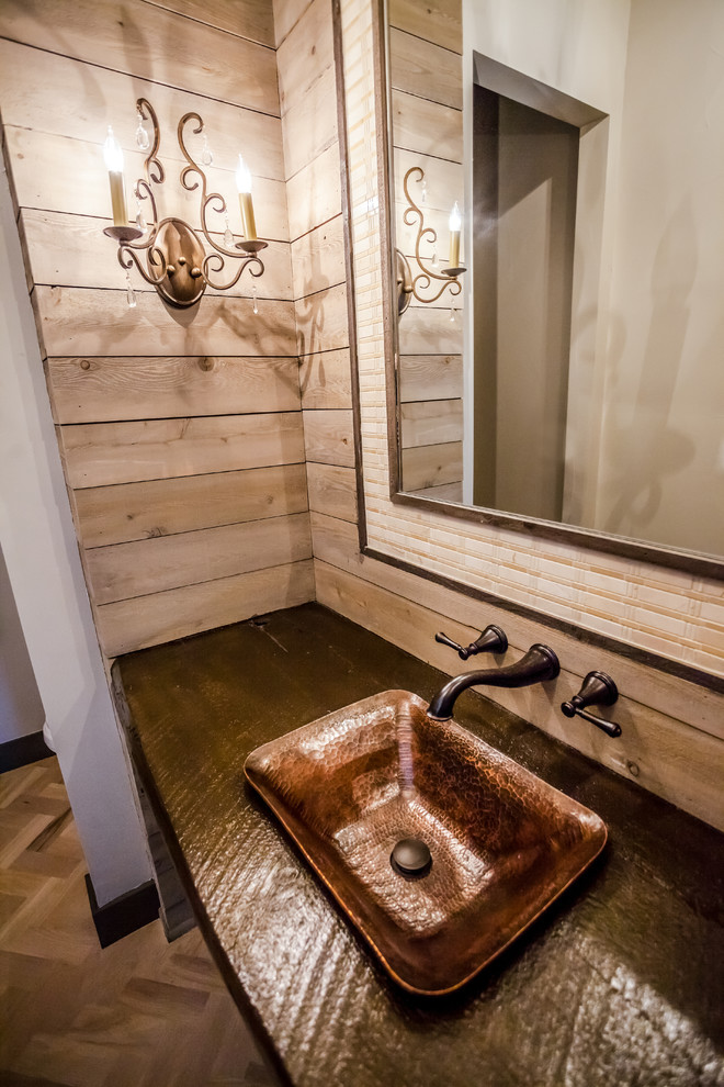 Design ideas for a medium sized rustic cloakroom in Minneapolis with freestanding cabinets, dark wood cabinets, a one-piece toilet, light hardwood flooring, a vessel sink, wooden worktops, brown tiles, beige walls and beige floors.