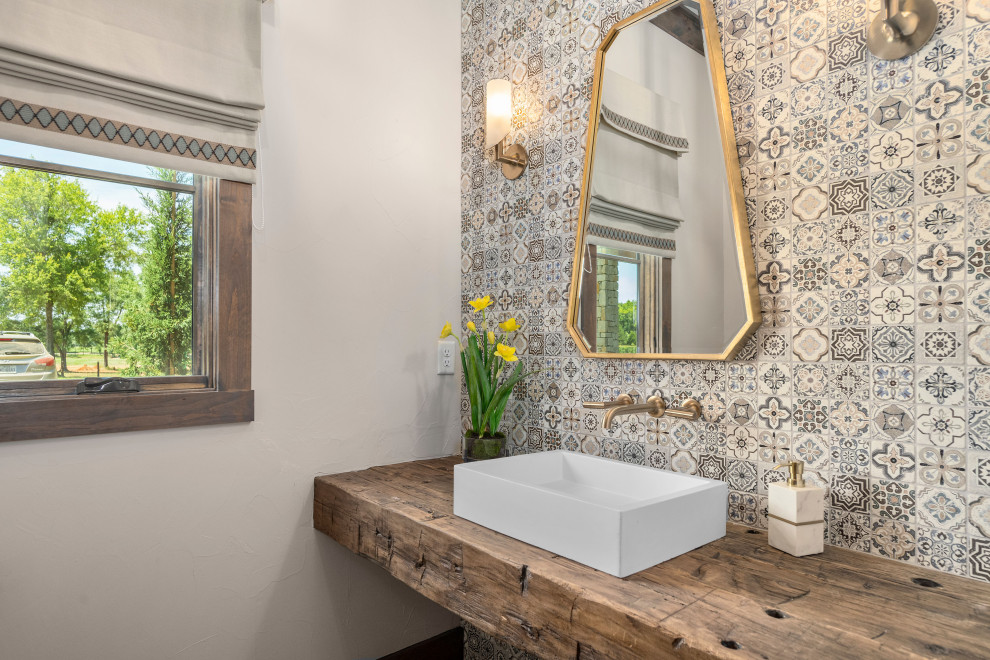 オースティンにあるカントリー風のおしゃれなトイレ・洗面所 (マルチカラーのタイル、白い壁、ベッセル式洗面器、木製洗面台、ブラウンの洗面カウンター) の写真