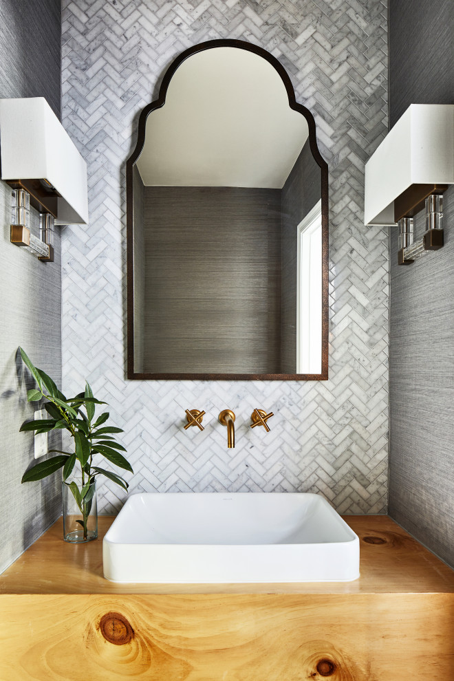 This is an example of a small beach style cloakroom in Chicago with open cabinets, light wood cabinets, a two-piece toilet, grey tiles, stone tiles, grey walls, dark hardwood flooring, a vessel sink, wooden worktops, brown floors, brown worktops, a floating vanity unit and wallpapered walls.
