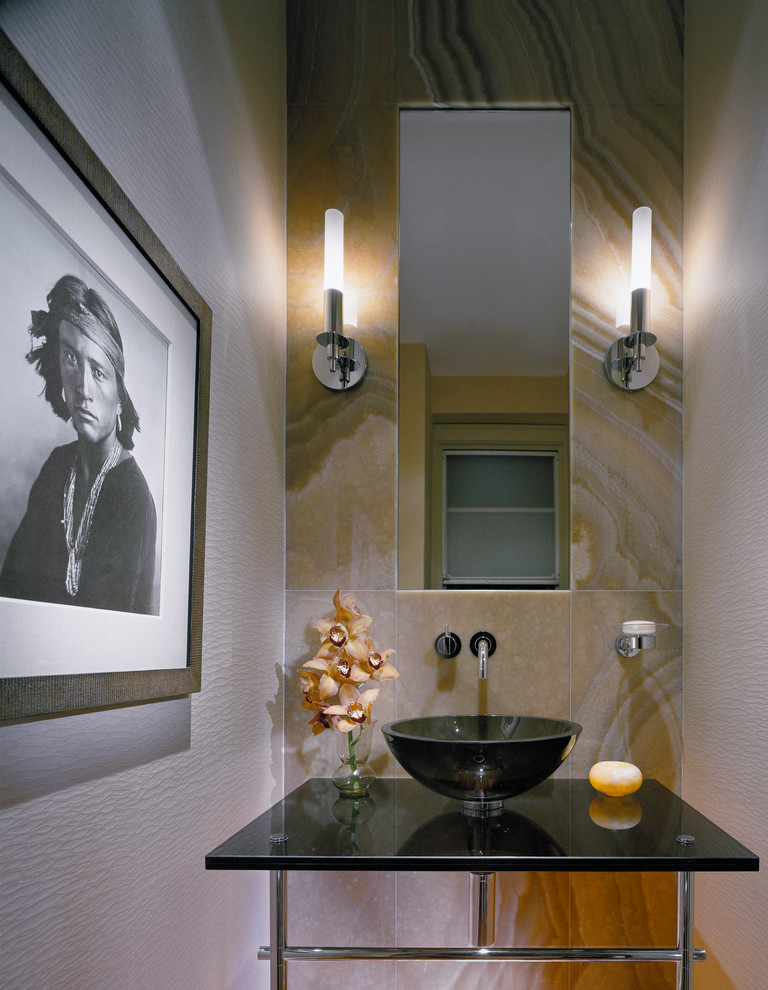 ワシントンD.C.にあるラグジュアリーなコンテンポラリースタイルのおしゃれなトイレ・洗面所 (ベッセル式洗面器、ガラスの洗面台、ベージュのタイル、石タイル) の写真