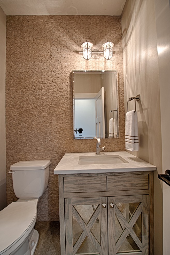 Klassisk inredning av ett litet toalett, med möbel-liknande, skåp i slitet trä, en toalettstol med separat cisternkåpa, beige kakel, stenkakel, beige väggar, betonggolv, ett väggmonterat handfat och bänkskiva i kvarts