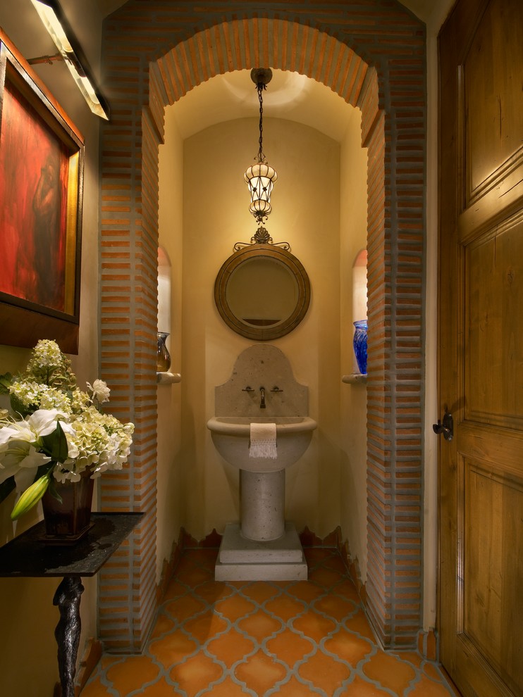 Bild på ett stort medelhavsstil toalett, med ett piedestal handfat, beige väggar, klinkergolv i terrakotta, orange kakel och perrakottakakel