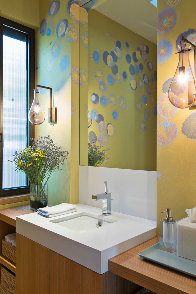 Idee per un bagno di servizio design con lavabo sottopiano, ante lisce, ante in legno scuro e pareti multicolore