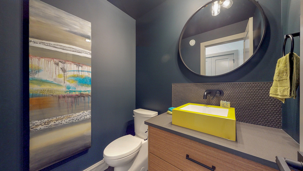 Cette image montre un WC et toilettes design en bois brun avec un placard à porte plane, un mur gris, une vasque et un plan de toilette gris.