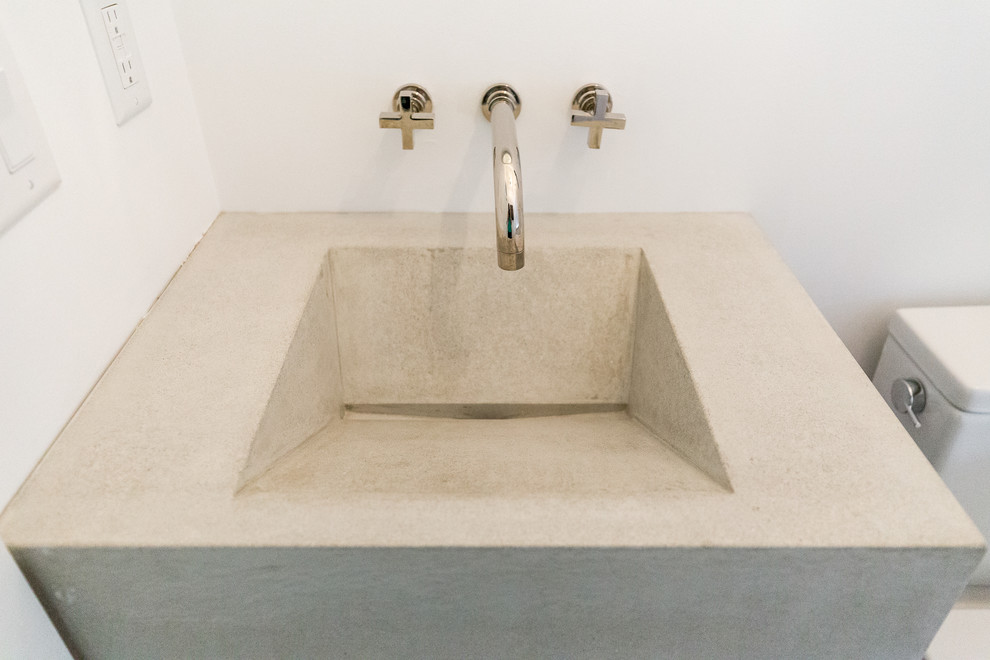Foto de aseo moderno pequeño con sanitario de dos piezas, paredes blancas, suelo de madera en tonos medios, lavabo integrado, encimera de cemento y suelo gris