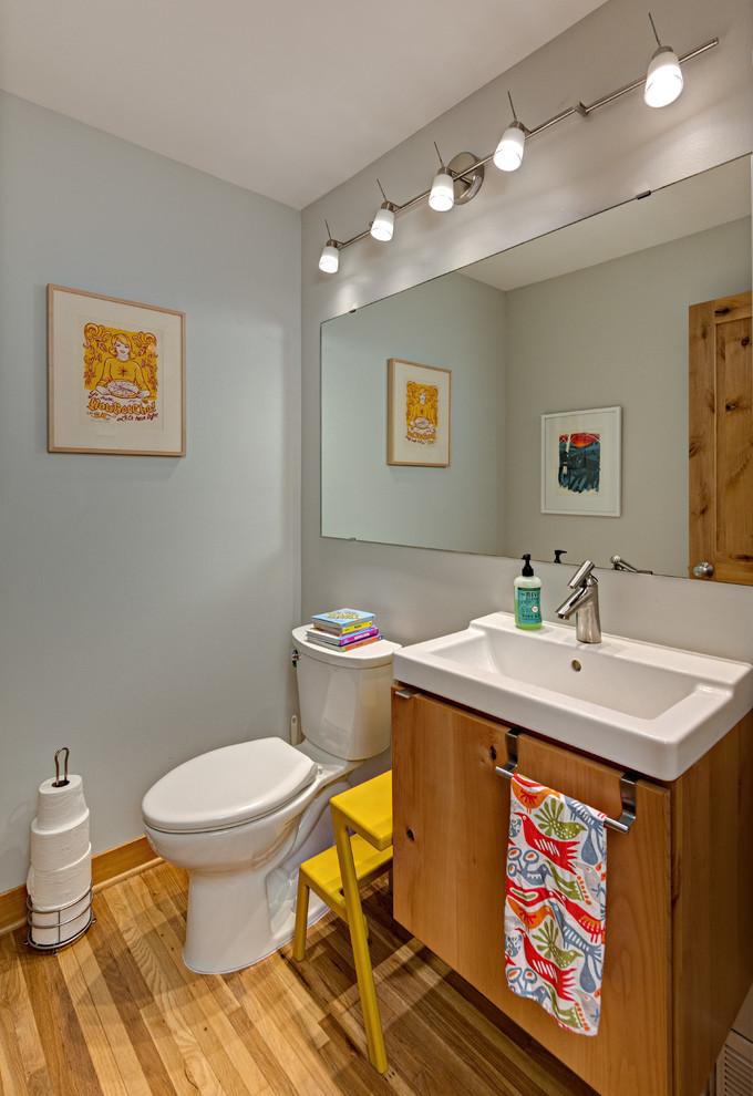 Inspiration för ett litet skandinaviskt toalett, med skåp i mellenmörkt trä, en toalettstol med separat cisternkåpa, vita väggar, mellanmörkt trägolv, släta luckor, ett integrerad handfat och brunt golv