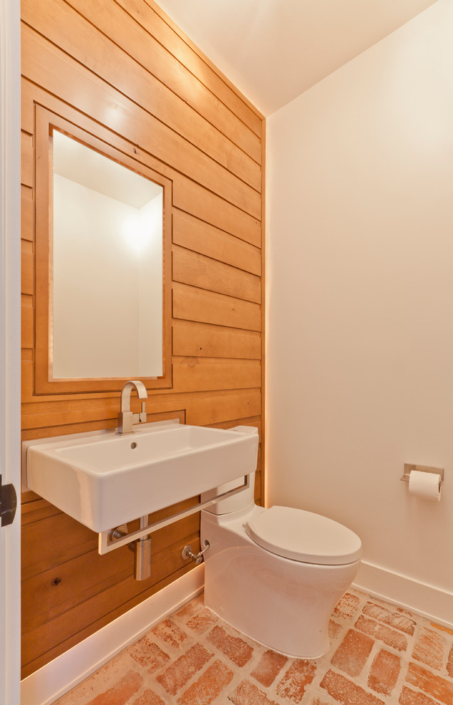 Exempel på ett litet minimalistiskt toalett, med släta luckor, skåp i mellenmörkt trä, en toalettstol med separat cisternkåpa, vita väggar, tegelgolv och ett väggmonterat handfat