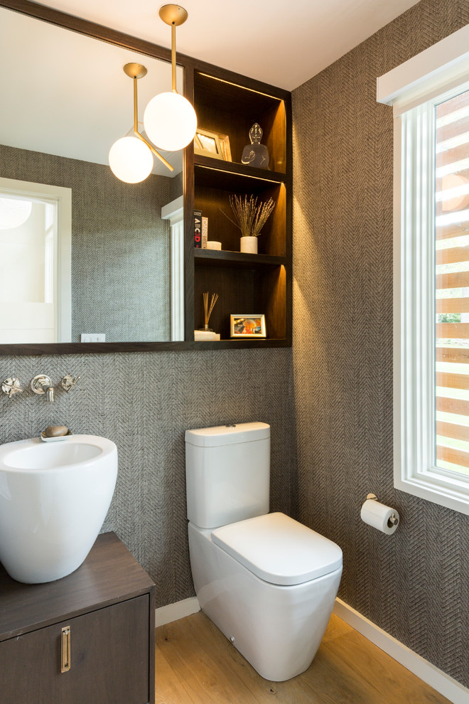 Ispirazione per un bagno di servizio minimalista di medie dimensioni con consolle stile comò, WC monopezzo, parquet chiaro e lavabo a bacinella