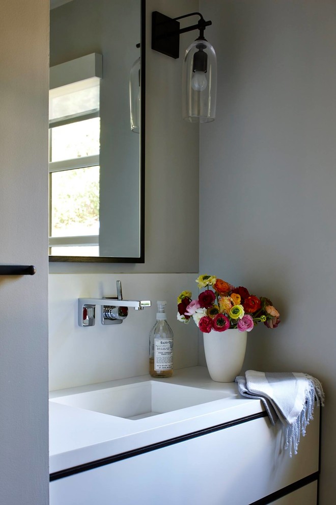 Ispirazione per un piccolo bagno di servizio minimal con lavabo integrato, ante lisce, ante bianche, top in superficie solida e WC monopezzo