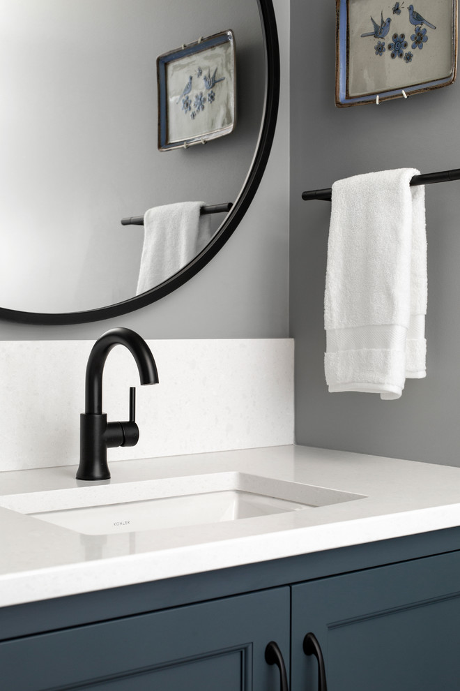 Idee per un piccolo bagno di servizio design con ante con riquadro incassato, ante blu, pareti grigie, lavabo sottopiano, top in superficie solida e top bianco