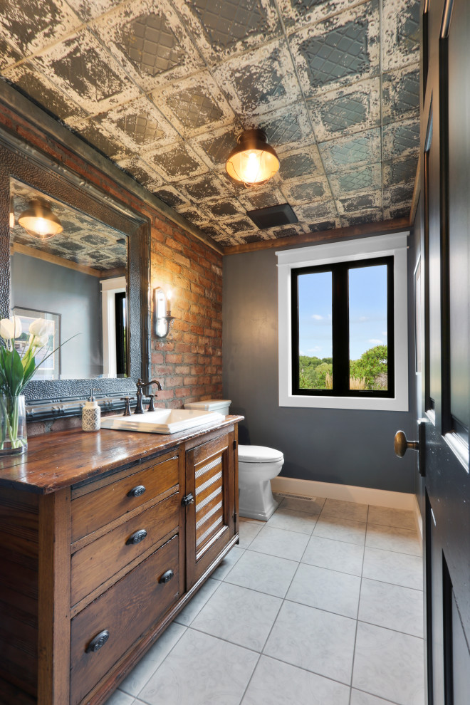 Inspiration for a country cloakroom in Other with recessed-panel cabinets, medium wood cabinets, a two-piece toilet, grey walls, a built-in sink, wooden worktops, grey floors and brown worktops.