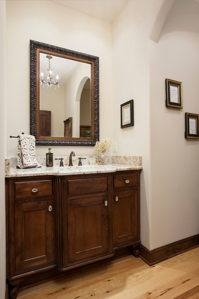 Exempel på ett mellanstort klassiskt toalett, med släta luckor, skåp i mellenmörkt trä, beige väggar, ljust trägolv, ett undermonterad handfat och granitbänkskiva