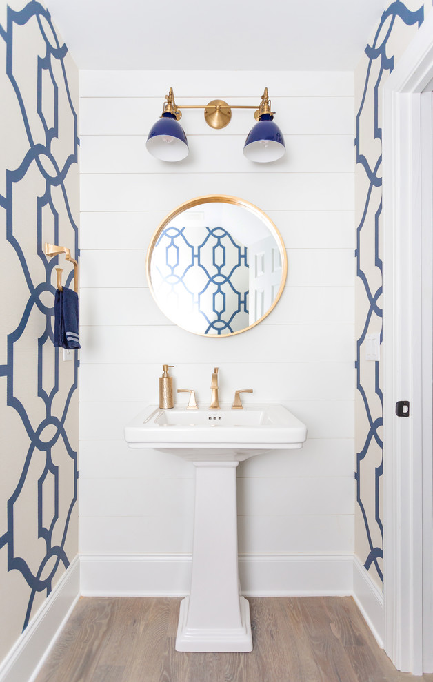 Exempel på ett mellanstort maritimt toalett, med blå väggar, ljust trägolv, ett piedestal handfat och grått golv