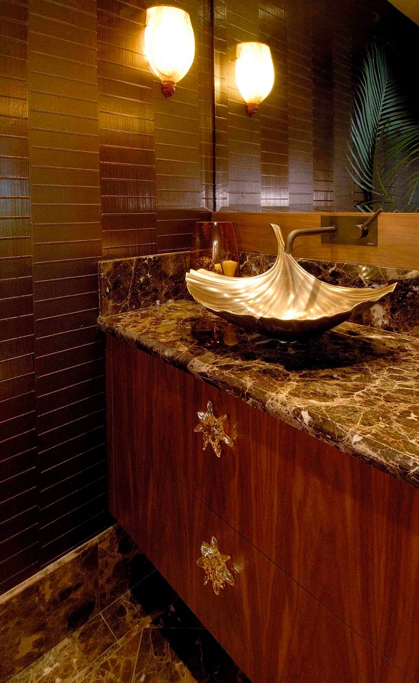 Inspiration for a tropical brown tile and stone tile marble floor powder room remodel in Hawaii with flat-panel cabinets, medium tone wood cabinets, a one-piece toilet, brown walls, a vessel sink and marble countertops