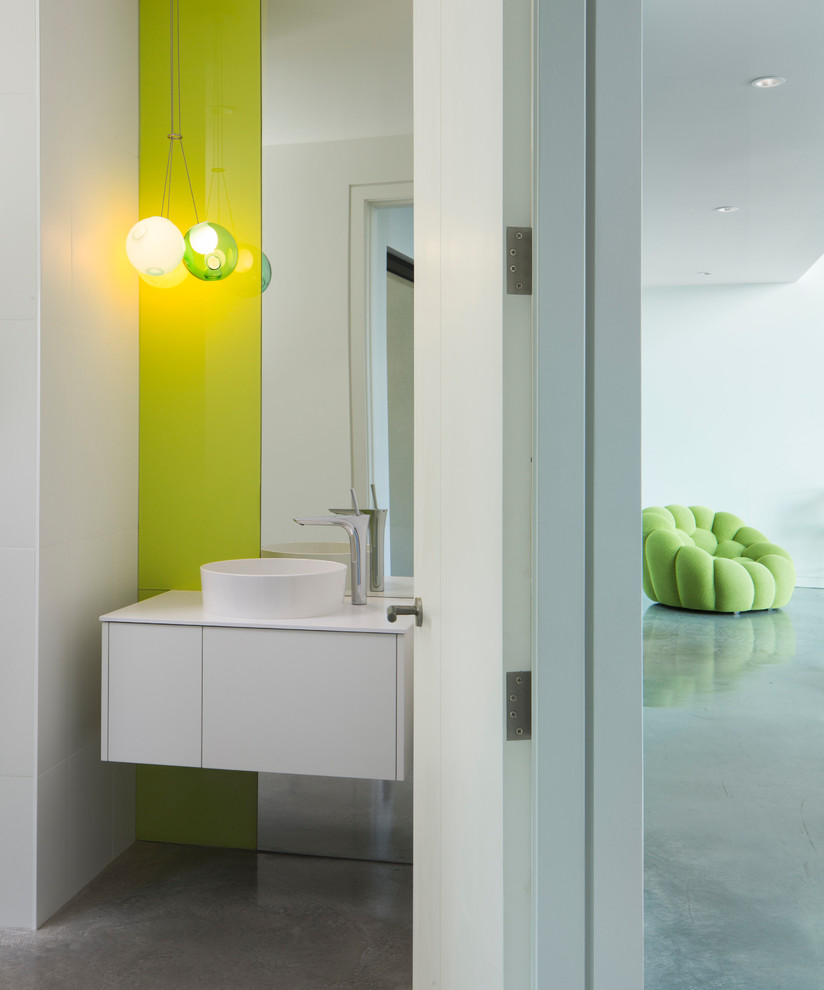 Kleine Moderne Gästetoilette mit flächenbündigen Schrankfronten, weißen Schränken, weißer Wandfarbe, Betonboden, Aufsatzwaschbecken, weißer Waschtischplatte und grauem Boden in Vancouver