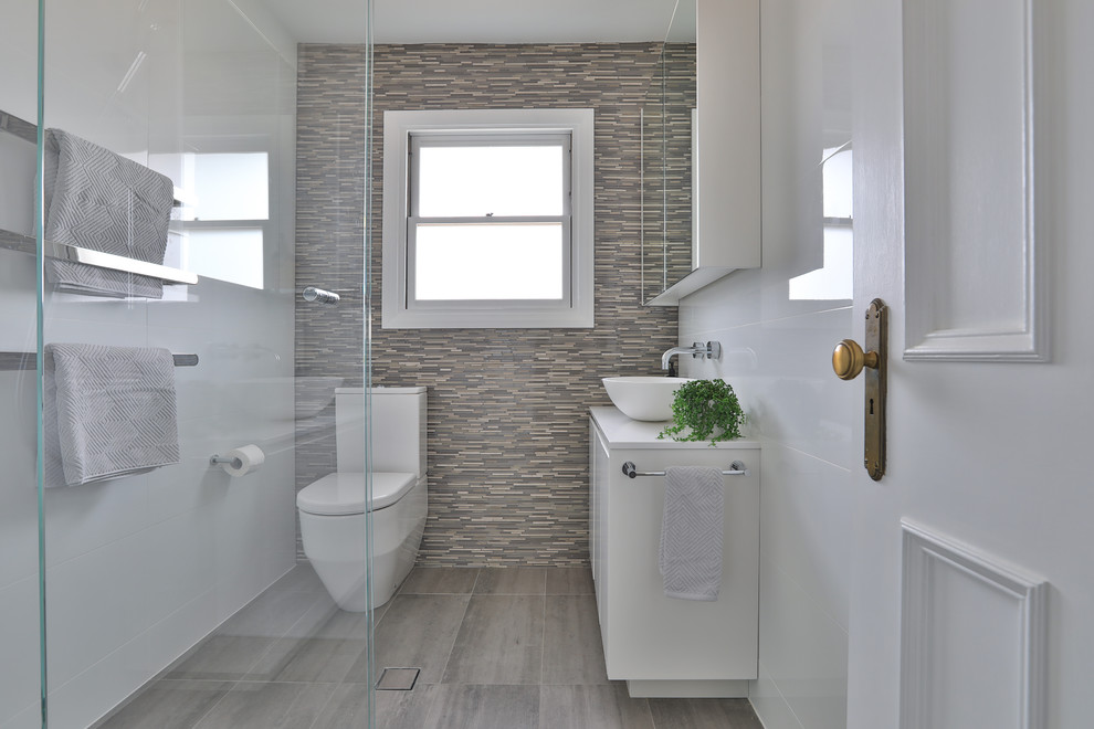 Powder room - mid-sized contemporary beige tile and matchstick tile ceramic tile and gray floor powder room idea in Sydney with white cabinets, quartz countertops, white countertops, a two-piece toilet, flat-panel cabinets and a vessel sink