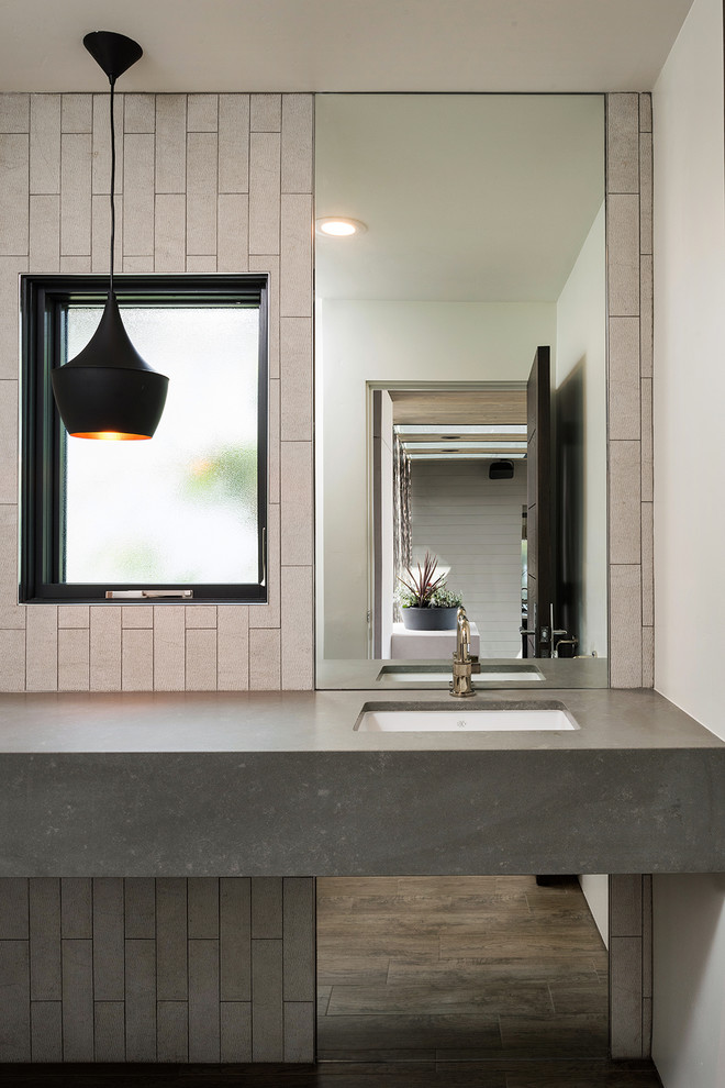 Immagine di un piccolo bagno di servizio contemporaneo con piastrelle grigie, pareti bianche, pavimento in gres porcellanato, lavabo sottopiano, top in quarzo composito, pavimento marrone e top grigio