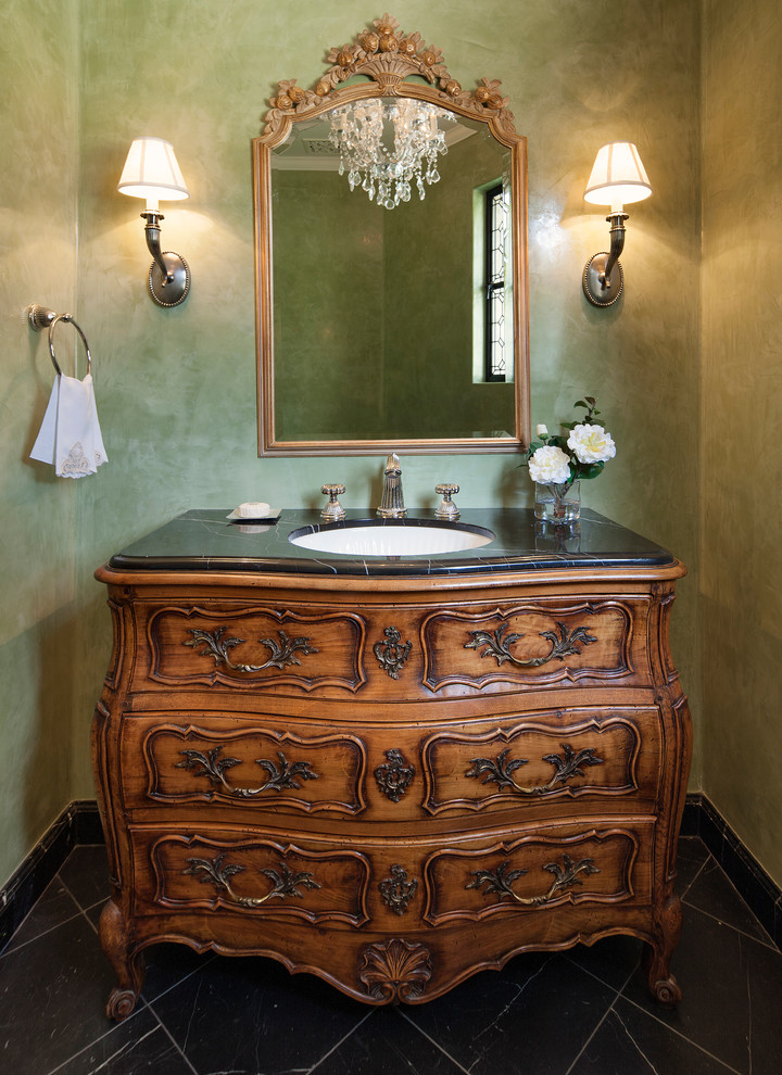 Cette image montre un WC et toilettes traditionnel en bois brun avec un lavabo encastré, un placard en trompe-l'oeil et un mur vert.