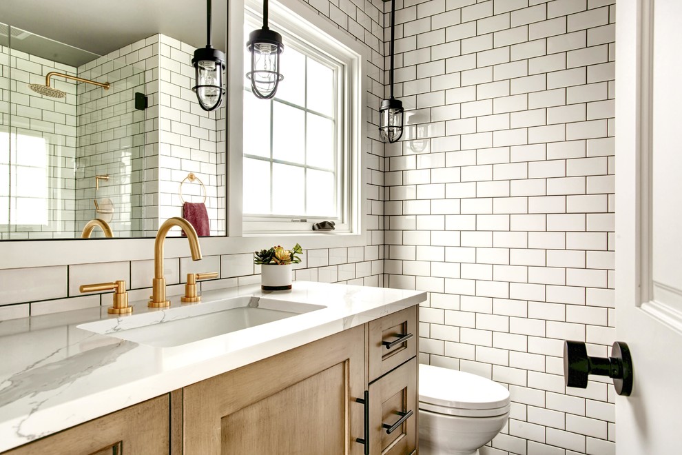 Example of a mid-sized transitional white tile and subway tile powder room design in Seattle with shaker cabinets, medium tone wood cabinets, white walls, a two-piece toilet, an undermount sink, quartzite countertops and white countertops