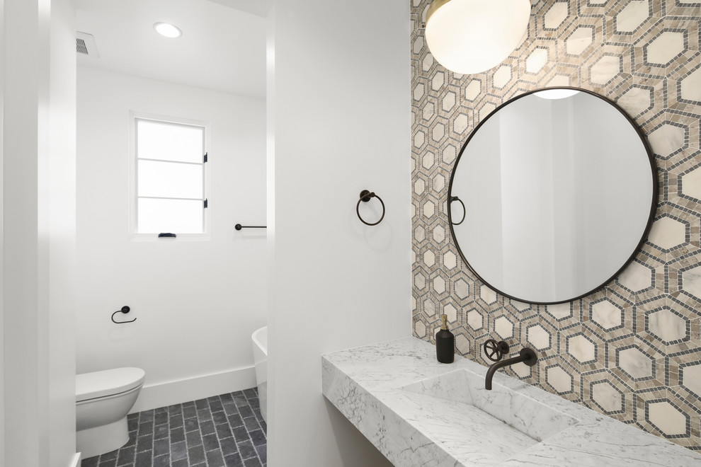 На фото: туалет среднего размера в стиле модернизм с унитазом-моноблоком, белыми стенами, монолитной раковиной, мраморной столешницей, серым полом, открытыми фасадами, разноцветной плиткой и полом из керамической плитки