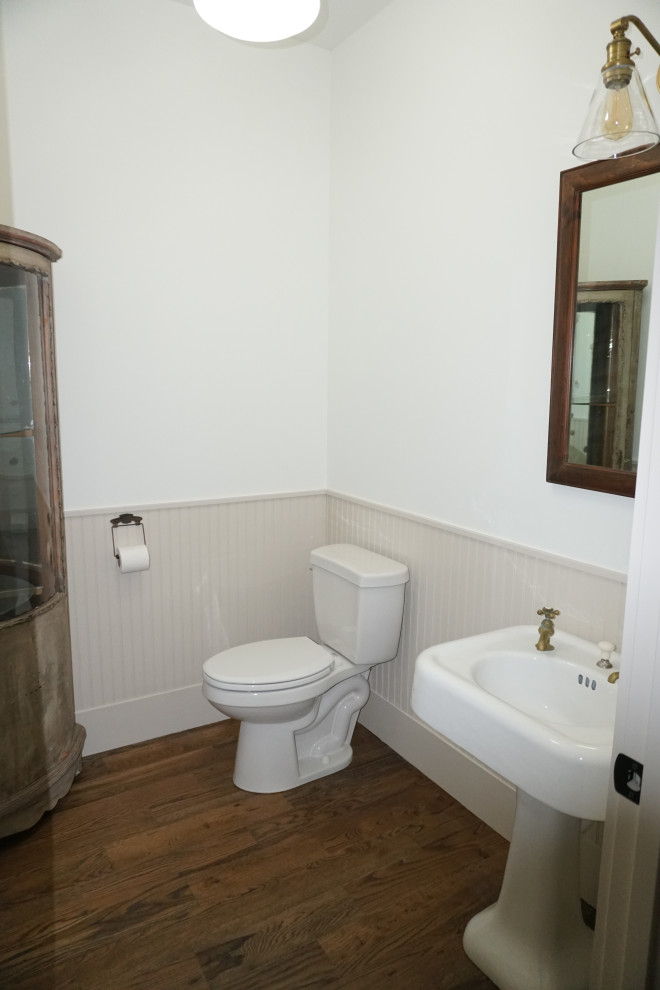 Esempio di un bagno di servizio country di medie dimensioni con pareti bianche, parquet scuro, lavabo a colonna e pavimento marrone