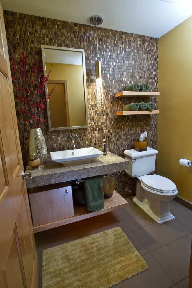 This is an example of a small traditional cloakroom in Other with a vessel sink, flat-panel cabinets, light wood cabinets, granite worktops, a two-piece toilet, brown tiles, beige tiles, beige walls, porcelain flooring and grey floors.
