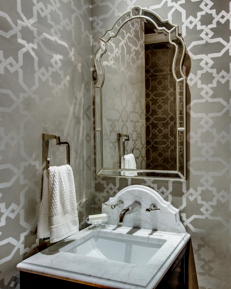 Immagine di un piccolo bagno di servizio tradizionale con WC a due pezzi, pareti marroni, pavimento in legno massello medio, lavabo sottopiano e top in marmo