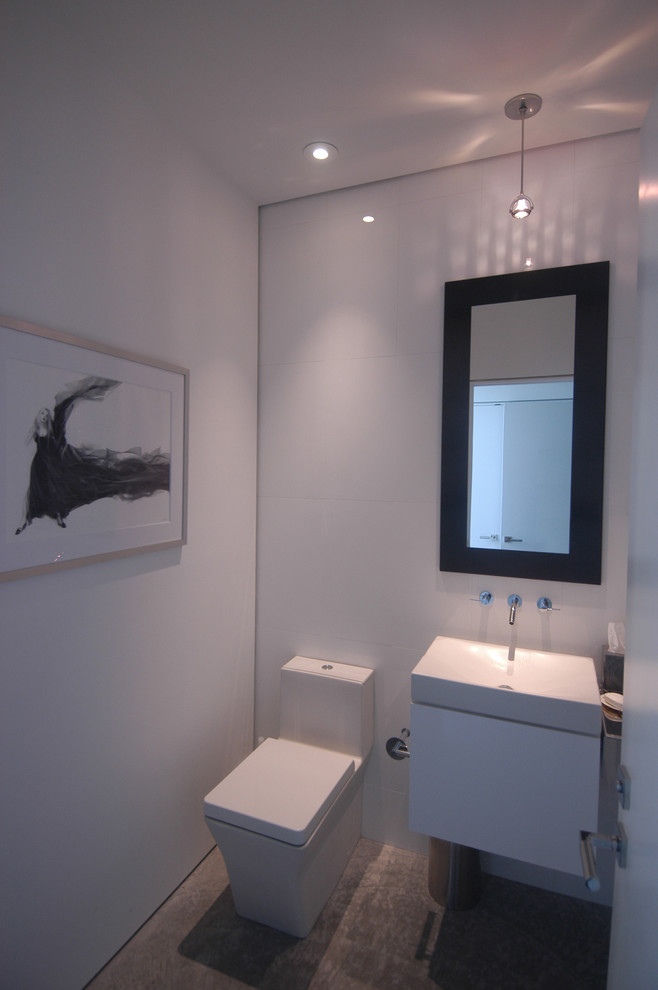 Photo of a small contemporary cloakroom in Miami with a vessel sink, flat-panel cabinets, white cabinets, a one-piece toilet, white tiles, porcelain tiles, white walls and concrete flooring.