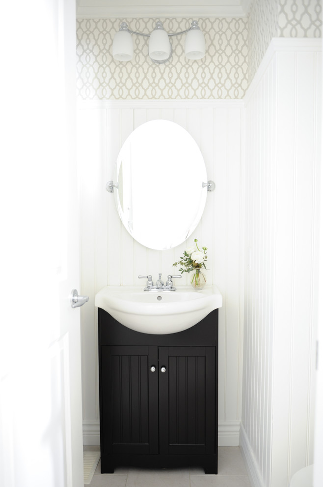 バンクーバーにあるお手頃価格の小さなトランジショナルスタイルのおしゃれなトイレ・洗面所 (一体型シンク、黒いキャビネット、白い壁、セラミックタイルの床、落し込みパネル扉のキャビネット、照明) の写真