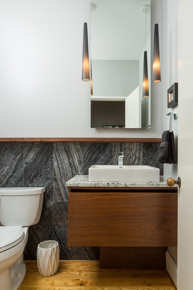 アトランタにあるコンテンポラリースタイルのおしゃれなトイレ・洗面所 (フラットパネル扉のキャビネット、濃色木目調キャビネット、分離型トイレ、黒いタイル、白い壁、無垢フローリング、ベッセル式洗面器、茶色い床) の写真