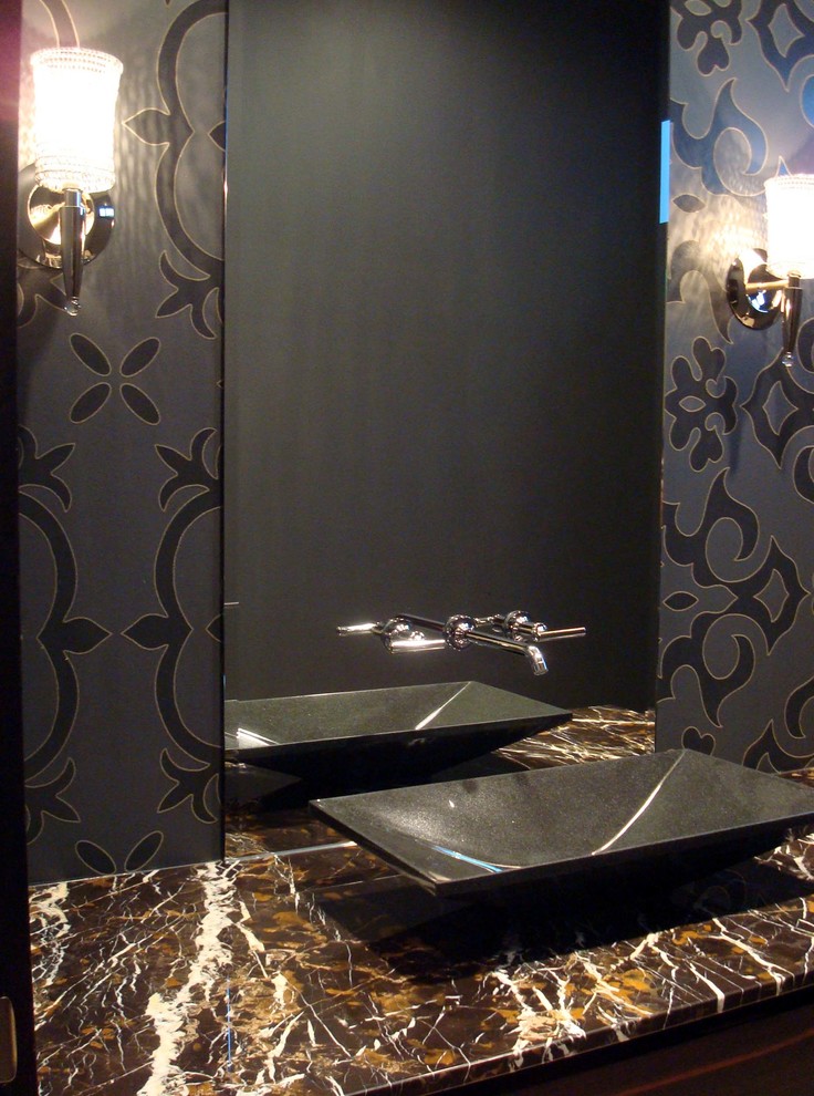 Example of a mid-sized trendy powder room design in Other with flat-panel cabinets, dark wood cabinets, a one-piece toilet, black walls, a vessel sink and marble countertops