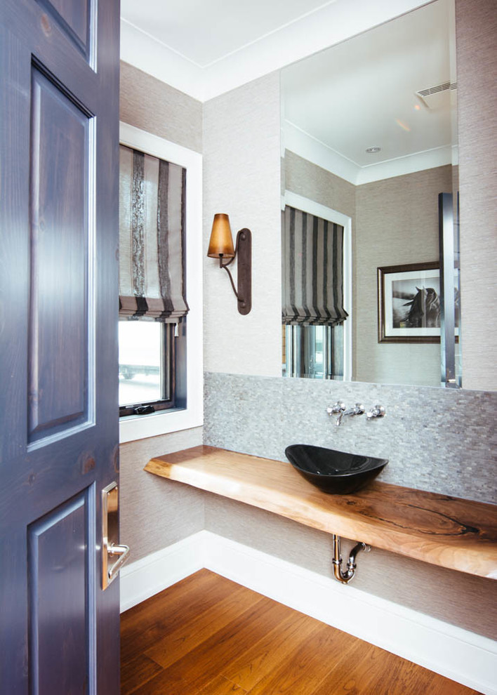 Small traditional cloakroom in Toronto with grey tiles, matchstick tiles, grey walls, medium hardwood flooring, a vessel sink, wooden worktops and brown floors.