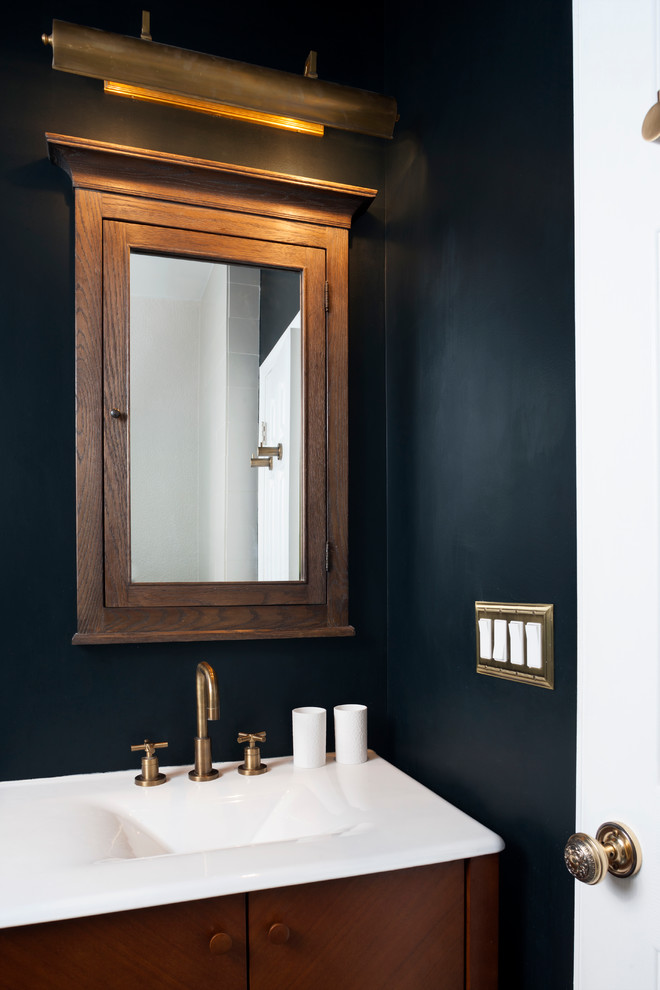 Inspiration for a mid-sized eclectic powder room remodel in DC Metro with dark wood cabinets, black walls and an integrated sink